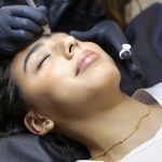 Stylist doing the eyebrows of a girl